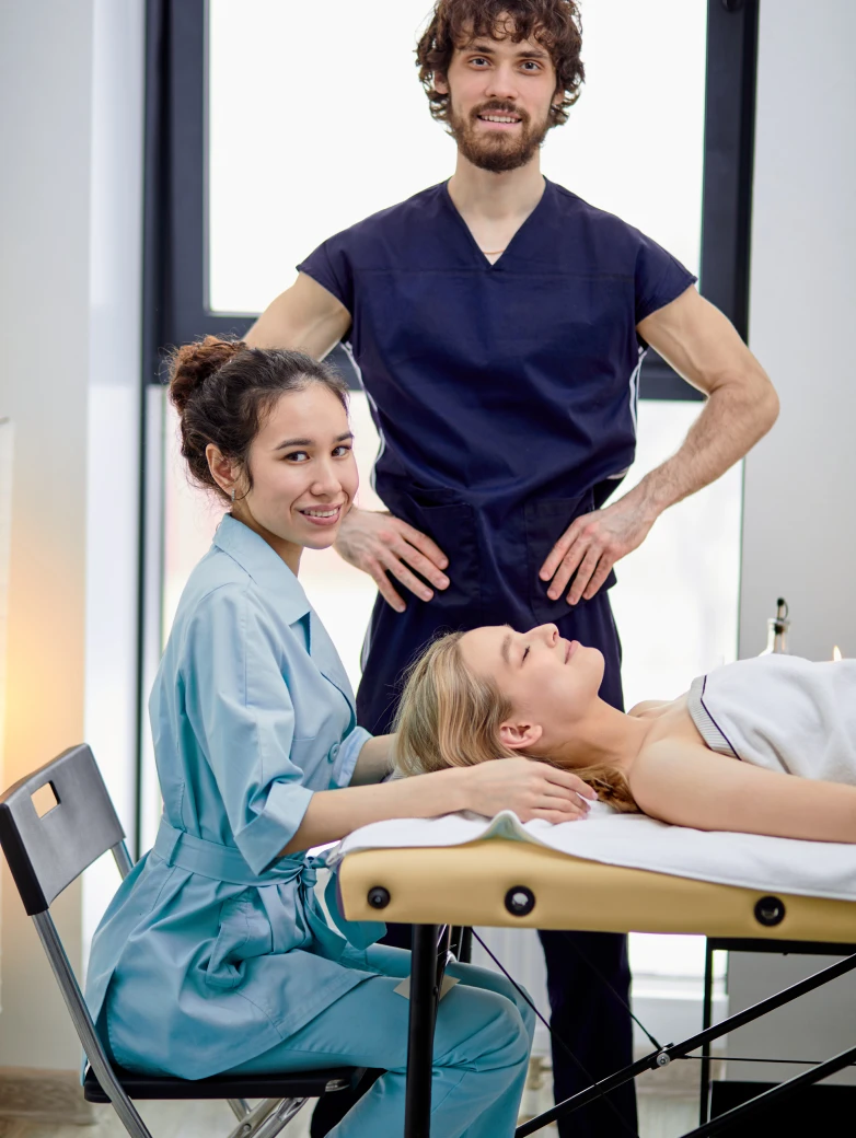 A certified and experienced physiotherapist smiling confidently at the clinic.